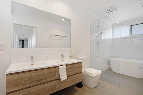 a bathroom with a sink and a tub and a toilet at The Dolphin Cottage - 250m to bay beach in Rye