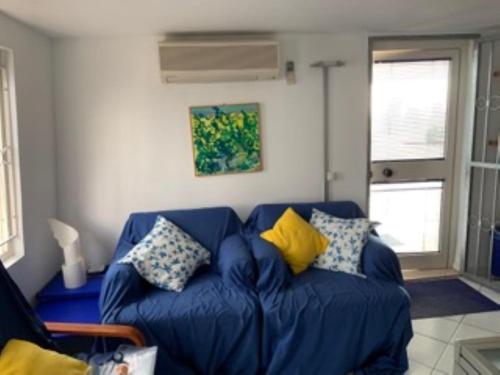 un sofá azul con almohadas en la sala de estar en L14 Bilocale in residence con piscina, en Porto Recanati