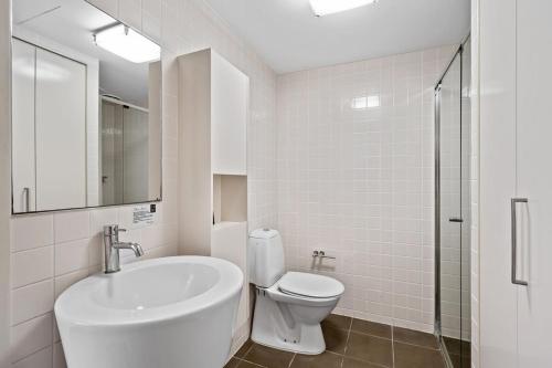 a white bathroom with a toilet and a sink at City Living - Brisbane River-View 2 bedroom Apt in Brisbane