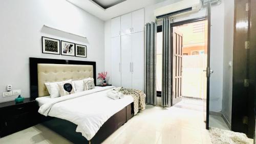 1 dormitorio con 1 cama grande y puerta corredera de cristal en BluO Modern 1BHK - DLF Galleria, en Gurgaon