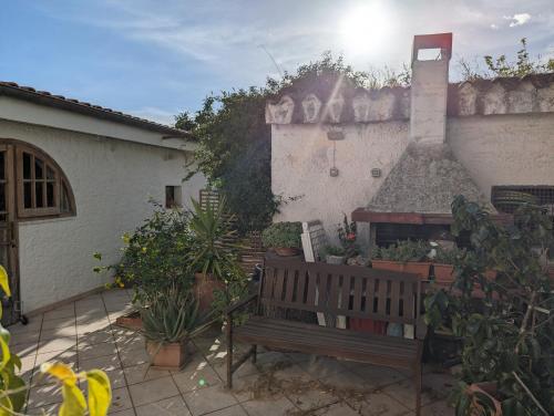 un banco frente a un edificio con plantas en Villa del Capitano, en SantʼAndrea