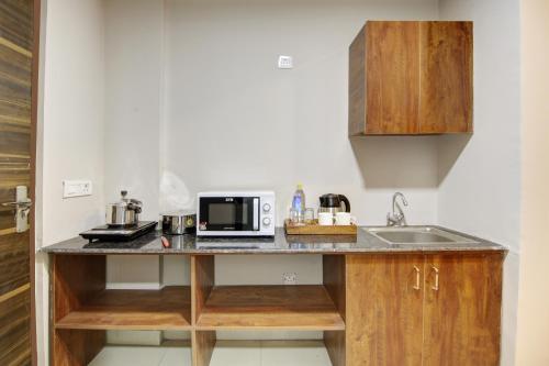 a kitchen with a sink and a microwave on a counter at Limewood Stay - Executive Huda City Center in Gurgaon