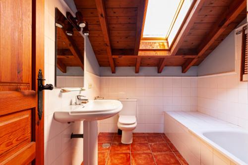 bagno con lavandino, servizi igienici e lucernario. di Casa Angel Caldueño 