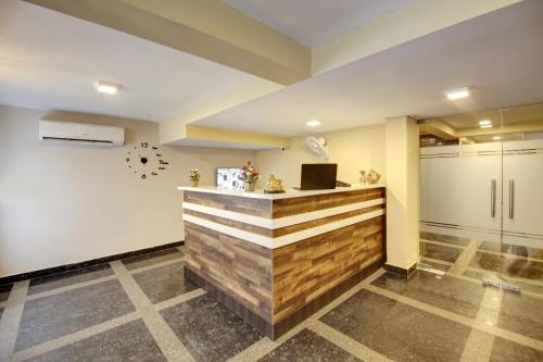 a lobby with a counter with a clock on the wall at Limewood Stay - Executive Huda City Center in Gurgaon