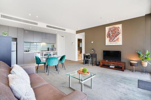 a living room with a couch and a table at Grosvenor on Queens Luxury Melbourne CBD Apt in Melbourne