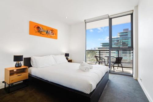 a bedroom with a bed and a large window at Grosvenor on Queens Luxury Melbourne CBD Apt in Melbourne