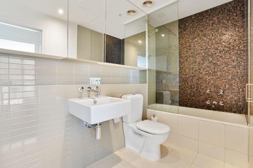 a bathroom with a toilet and a sink at Grosvenor on Queens Luxury Melbourne CBD Apt in Melbourne