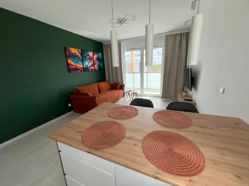 ein Wohnzimmer mit einem Tisch und einem Sofa in der Unterkunft Glazurowa apartament Trójmiasto in Danzig