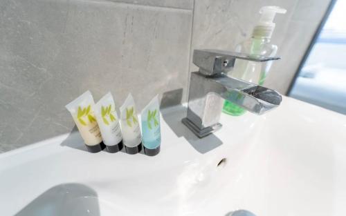 a bathroom sink with a faucet and three toothbrushes at Compact STUDIOS near the city in Selly Oak in Birmingham