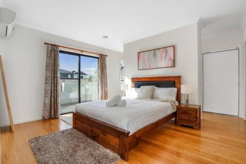 een slaapkamer met een bed en een groot raam bij Bundoora Family Home near Uni Hill in Bundoora