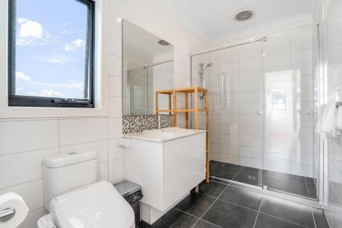 een witte badkamer met een toilet en een douche bij Bundoora Family Home near Uni Hill in Bundoora