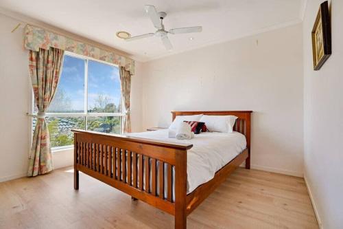 een slaapkamer met een bed en een groot raam bij Prized Home Away from Home in Enviable Location in Narre Warren South