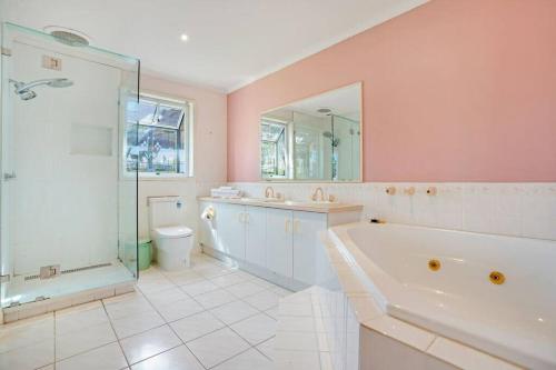 y baño con bañera, ducha y aseo. en Prized Home Away from Home in Enviable Location, en Narre Warren South