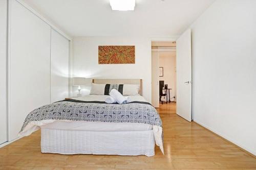 a white bedroom with a large bed in it at Humble Abode @Footscray (CBD Accessible) in Melbourne