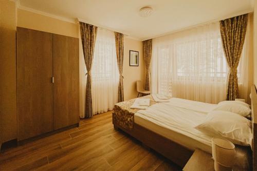 a bedroom with a large bed and a window at Hizha Martsiganitsa in Asenovgrad