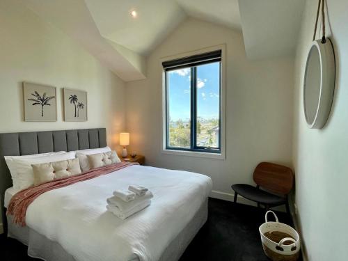 a bedroom with a large bed and a window at Amazing Beachfront & City Views 2 bed 2 bathroom in Melbourne