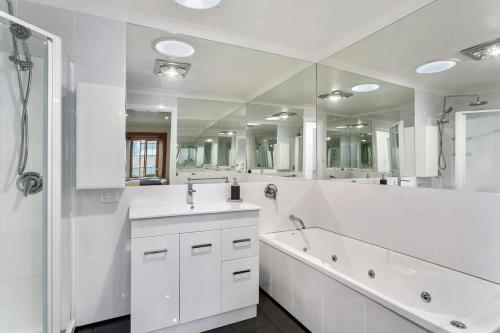荷伯特的住宿－Heritage Building Penthouse CBD Apartment，一间带水槽和大镜子的浴室
