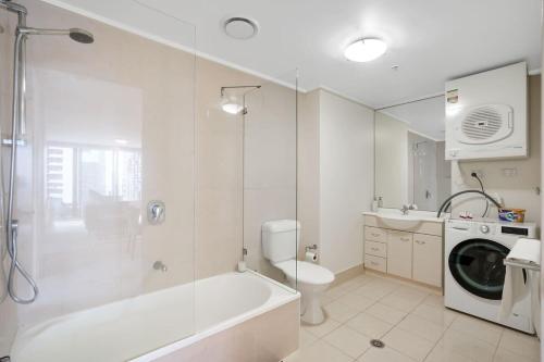 uma casa de banho com uma banheira, um WC e uma máquina de lavar roupa em Spacious&Cozy 2 bedroom City Point Melbourne Apt em Melbourne
