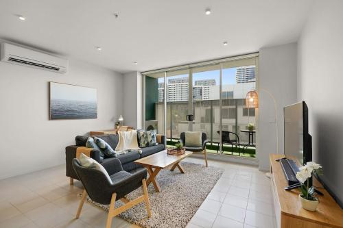 a living room with a couch and a table at A River-side 2bdm Footscray Oasis + Parking in Melbourne