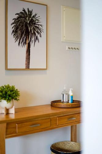 a room with a wooden table with a palm tree on the wall at A River-side 2bdm Footscray Oasis + Parking in Melbourne