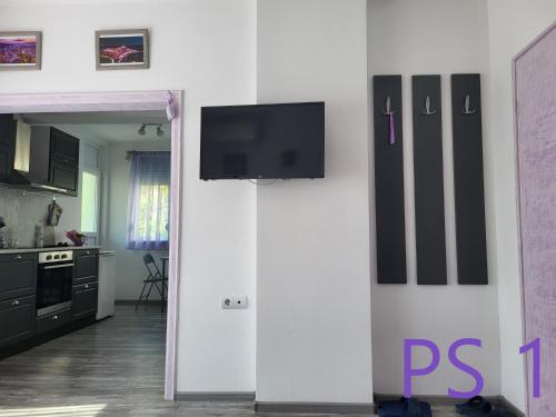 a living room with a tv on a white wall at Purple StudioS in Veliko Tŭrnovo