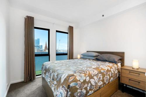 a bedroom with a bed and a large window at Panoramic View CBD 1 Bed Apt +OFFICE (Collins) in Melbourne