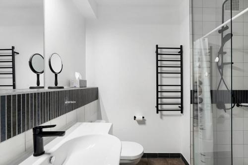 uma casa de banho com WC, lavatório e espelho em Panoramic View CBD 1 Bed Apt +OFFICE (Collins) em Melbourne