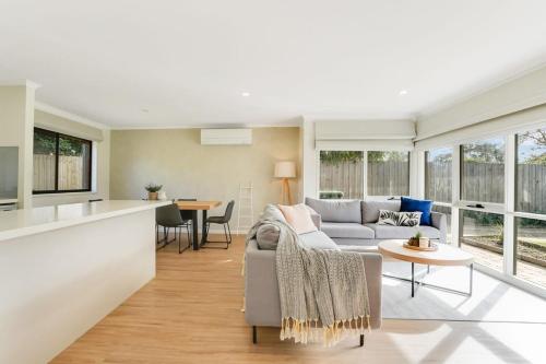 a living room and kitchen with a couch and a table at Relaxed at Rosebud-Cosy 3 bedroom beach escape* in Rosebud