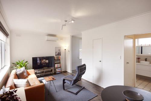 a living room with a couch and a chair at Central Classic Collingwood Modern Apt in Melbourne