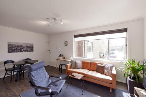 a living room with a couch and a table at Central Classic Collingwood Modern Apt in Melbourne
