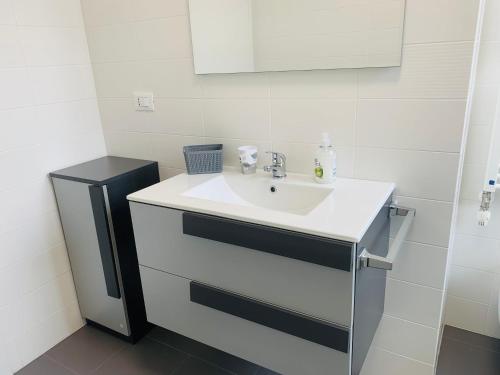 a bathroom with a white sink and a mirror at Deny & Carol's house in Somma Lombardo