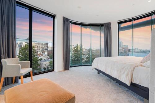 een slaapkamer met een bed en grote ramen bij Stylish Bay-Side Executive Apt w parking in Melbourne