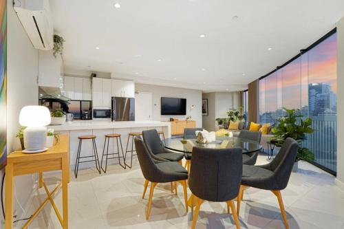 een keuken en een woonkamer met een tafel en stoelen bij Stylish Bay-Side Executive Apt w parking in Melbourne