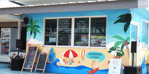 a restaurant with a blue wall with signs on it at Tongna Cottage Natural Resort in Chiang Mai