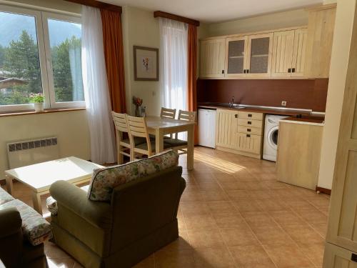 eine Küche und ein Wohnzimmer mit einem Sofa und einem Tisch in der Unterkunft Pirin Golf private studio in Raslog