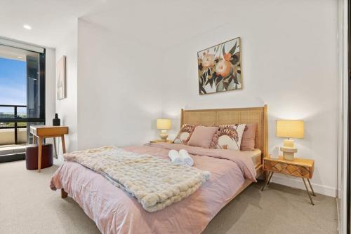 a bedroom with a large bed with two pillows at Brand New Box Hill Central Executive w pool+gym in Box Hill