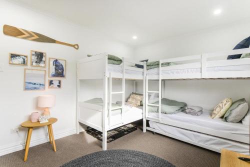 two bunk beds in a room with a table at Rye Getaway - Well Appointed & Cozy Family Home* in Rye