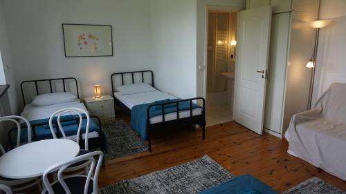 a small room with two beds and a table and chairs at Pensjonat Kowalski in Łubowo
