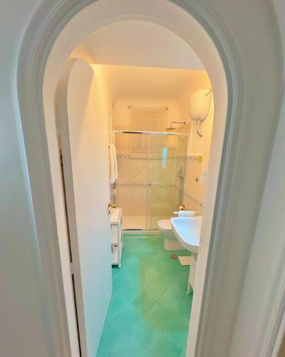 an archway leading to a bathroom with a toilet and sink at Villa Azul in Anacapri