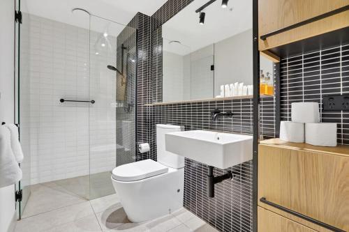 a bathroom with a toilet and a sink and a shower at Richmond Heritage Executive Apt for 2 w parking in Melbourne