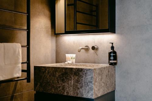 een badkamer met een wastafel en een fles zeep bij Luxurious Elsternwick Apt Living with Parking in Melbourne