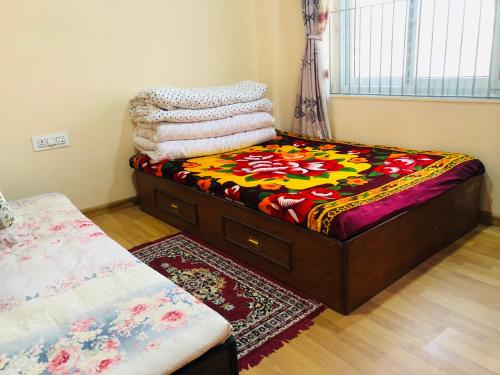 - une chambre avec un lit et une couverture colorée dans l'établissement Happy Kid's Nepal, à Katmandou
