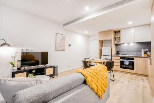 a living room with a couch and a table at Penny Lane - 2BR Apt in the Heart of Moonee Ponds in Melbourne
