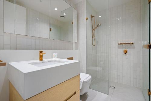 een witte badkamer met een wastafel en een toilet bij Premium CBD Location 19th floor Collins House Apt in Melbourne