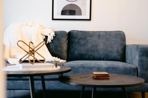 a living room with a blue couch and a table at Cozy Nest in Prime Hawthorn w parking & pool in Melbourne