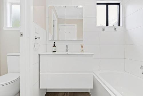 a white bathroom with a tub and a sink at Premiere Seaside Home - Relaxing Family Getaway* in Rye
