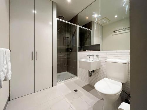 een badkamer met een toilet, een douche en een wastafel bij Explore Melbourne from this Chic 1BR in Windsor in Melbourne