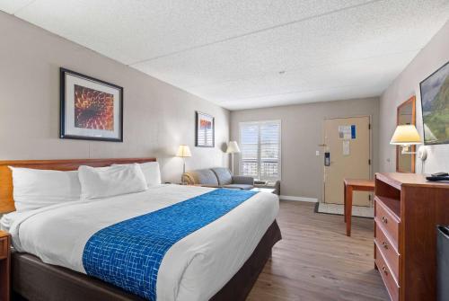 a hotel room with a bed and a desk at Travelodge by Wyndham Pueblo in Pueblo