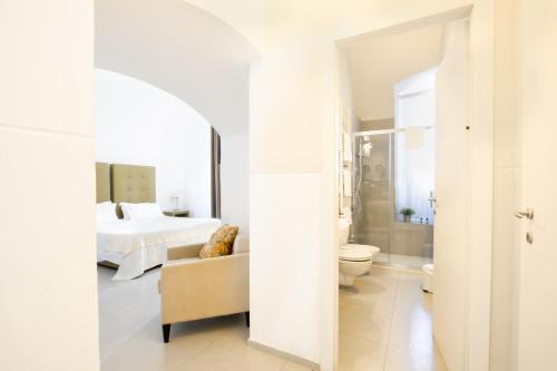 a white bedroom with a bed and a bathroom at Le Tre Sorelle in Bari