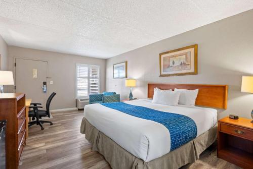 a hotel room with a large bed and a desk at Travelodge by Wyndham Pueblo in Pueblo